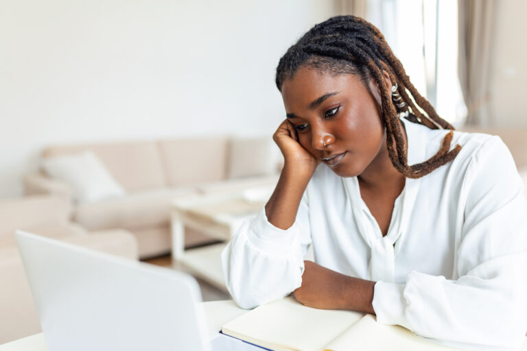 Mujer negra preocupada delante de un ordenador.
